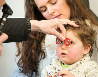 Child having eye examination with mother